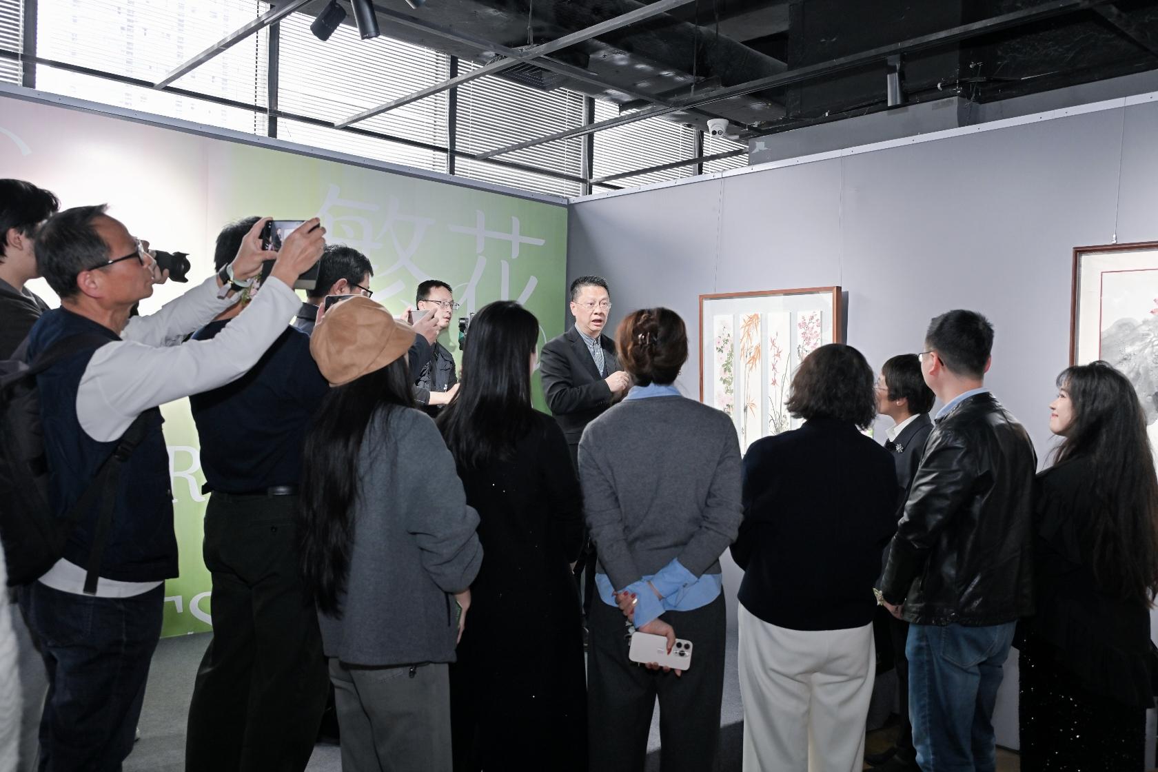 重庆美术馆(重庆画院)书记、馆(院)长王发荣向观众介绍作品